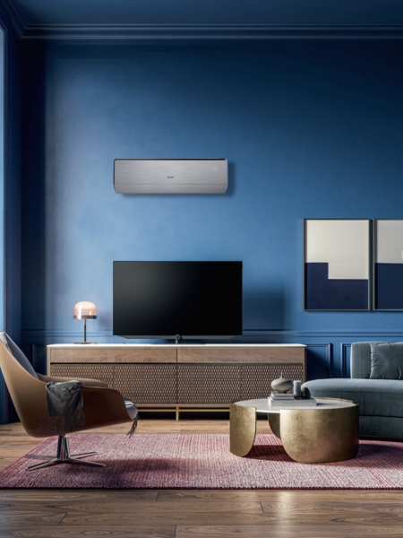 Ernst Winninger Kältetechnik zeigt ein Wohnzimmer mit moderner Einrichtung und kompakter Klimaanlage montiert an der Wand über dem Fernseher.