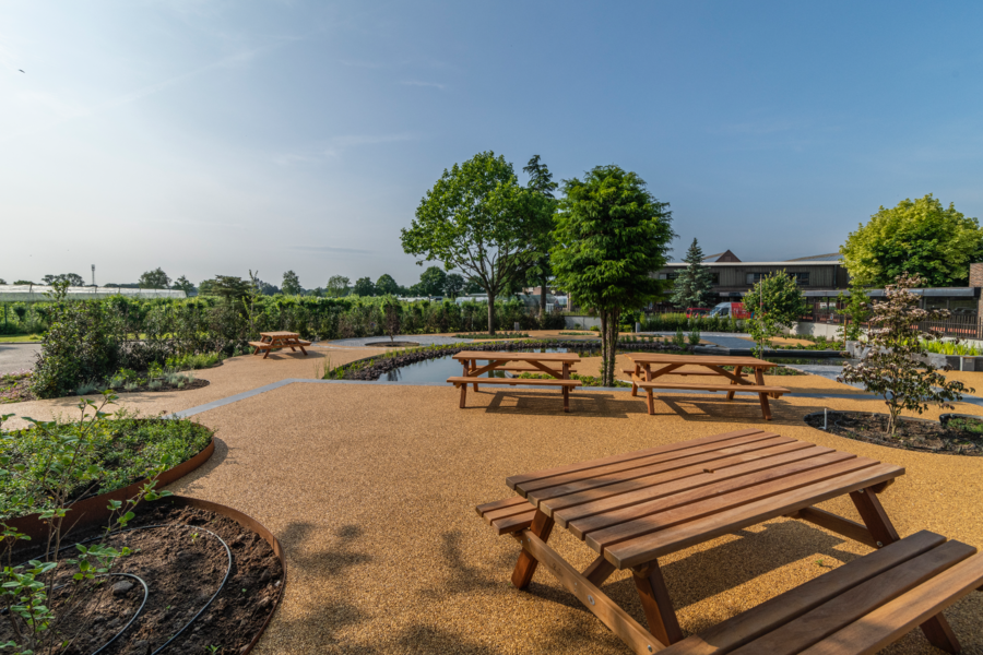 stoneCARPET zeigt eine Parkanlage mit Sitzbänken, einem Schwimmteich und Natursteinteppich.