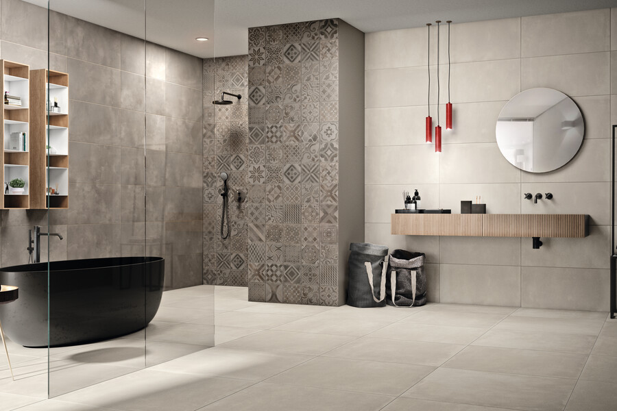 Fliesendorf präsentiert ein Badezimmer in hellen beige/grau Tönen mit einer schwarzen freistehenden Badewanne, mehreren Regalen, einem Waschtisch inklusive Waschbecken.