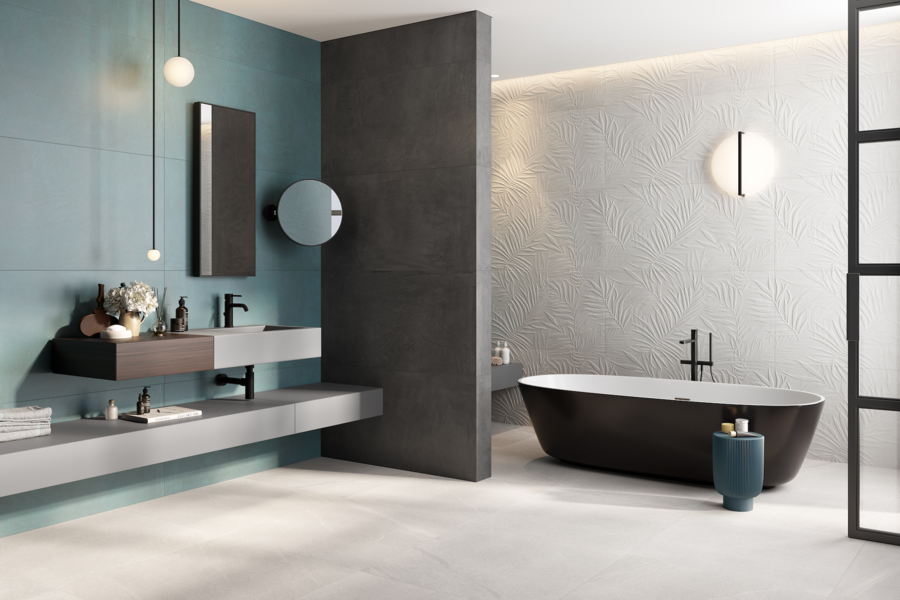 Fliesendorf zeigt ein Badezimmer mit blauen und grauen Wänden, hellgrauem Boden, einer freistehenden brauen Badewanne und Waschbecken.
