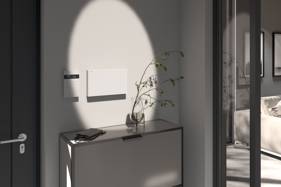 Gira präsentiert den Alarm Connect in weiß im Eingangsbereich einer modernen Wohnung, eingerichtet in verschiedenen Grautönen.