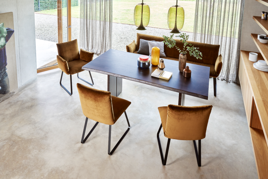 WOHNHAUS Grill & Ronacher zeigt eine Essgruppe bestehend aus einem Holztisch, Stühlen und einer Sitzbank in braun mit grünen Hängelampen aus Glas von Bielefelder Werkstätten.