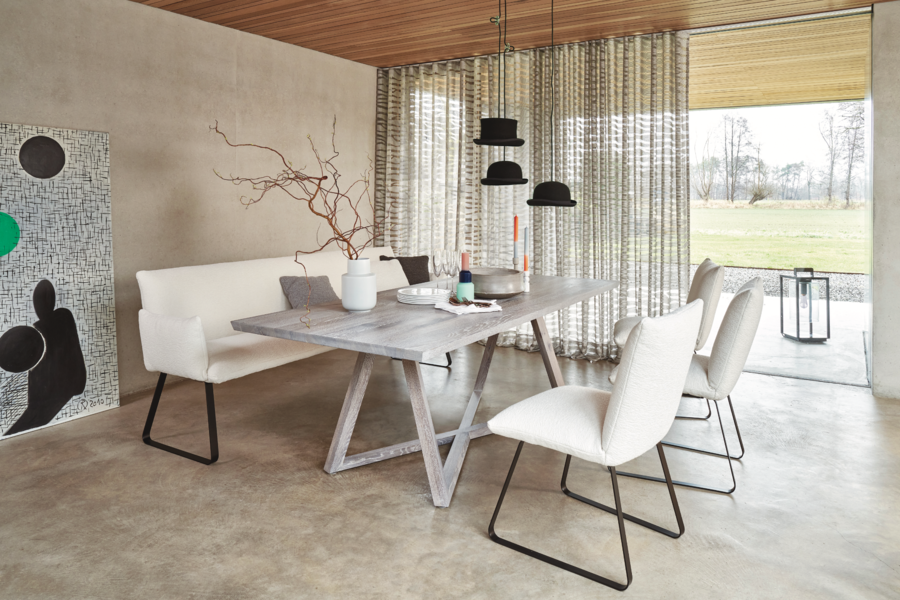 WOHNHAUS Grill & Ronacher zeigt ein Esszimmer mit hellem Holztisch, einer Sitzbank und weissen Stühlen mit einer Hängelampe aus Hüten von Bielefelder Werkstätten.