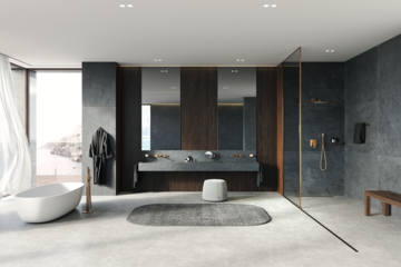 Grohe zeigt ein Badezimmer mit einem grauen Doppelwaschtisch, einer freistehenden Badewanne mit goldenen Armaturen und einer Dusche mit großer Glaswand.