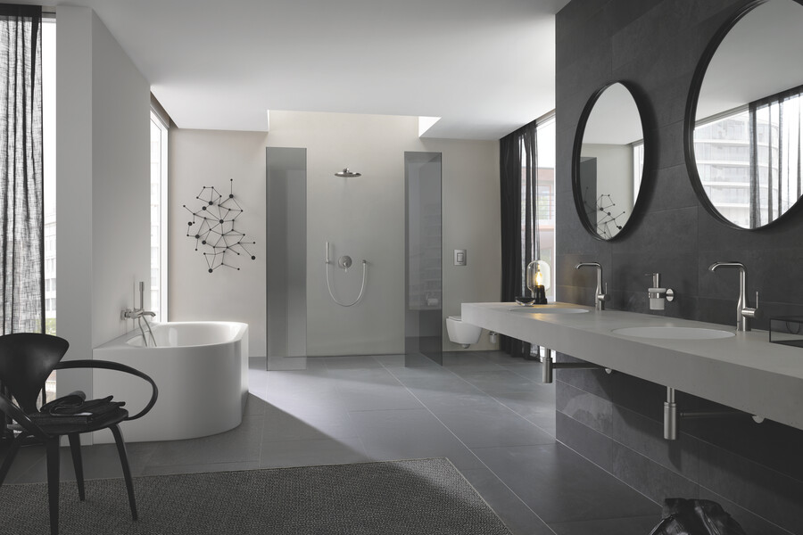 GROHE zeigt ein großes Badezimmer mit Doppelwaschtisch, großzügiger Duschkabine mit abgedunkeltem Glas und einer weißen Badewanne.