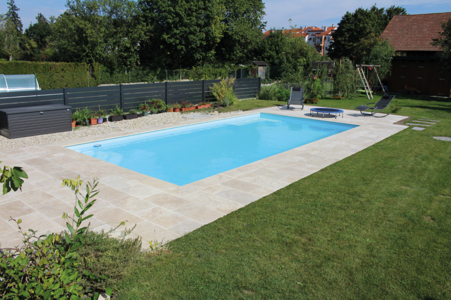 Garten mit Pool und heller Poolumrandung bestehend aus Steinplatten von Häusler.