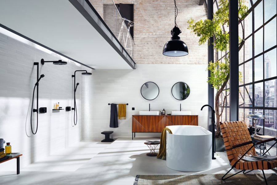 Hansgrohe präsentiert ein offenes Loft-Badezimmer mit schwarzen Armaturen, einer großen Badewanne, welches durch die vielen Fenster sehr ausgeleuchtet wird..