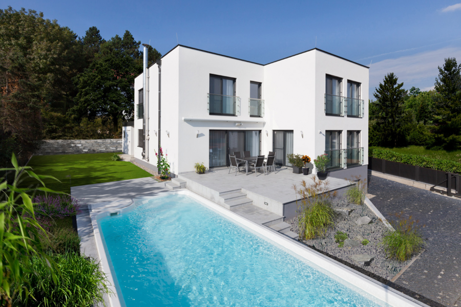 Modernes, zweistöckiges Fertigteilhaus mit Flachdach, Terrasse, deckenhohen Fenstern und Swimmingpool, erbaut von Hartl Haus.