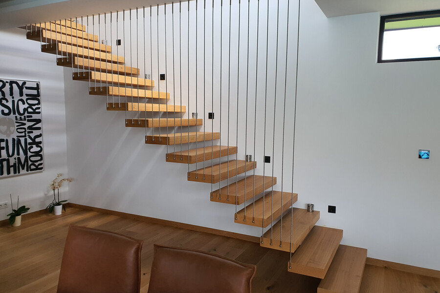 Hausjell zeigt eine Treppe aus Holz die auf Eisendrähten hängt vom Erdgeschoß in den ersten Stock.