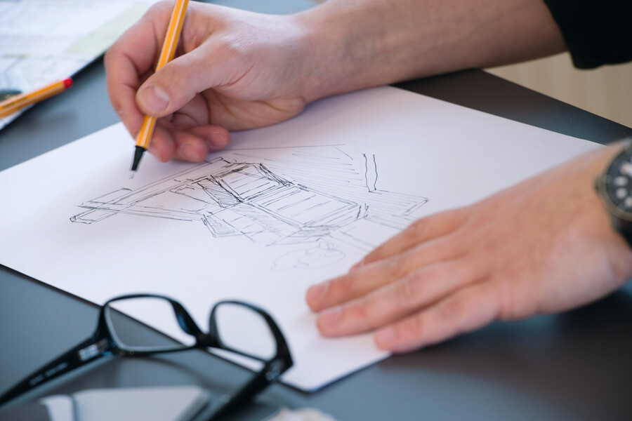 Internorm präsentiert einen Planer, der gerade ein neues Haus skizziert.