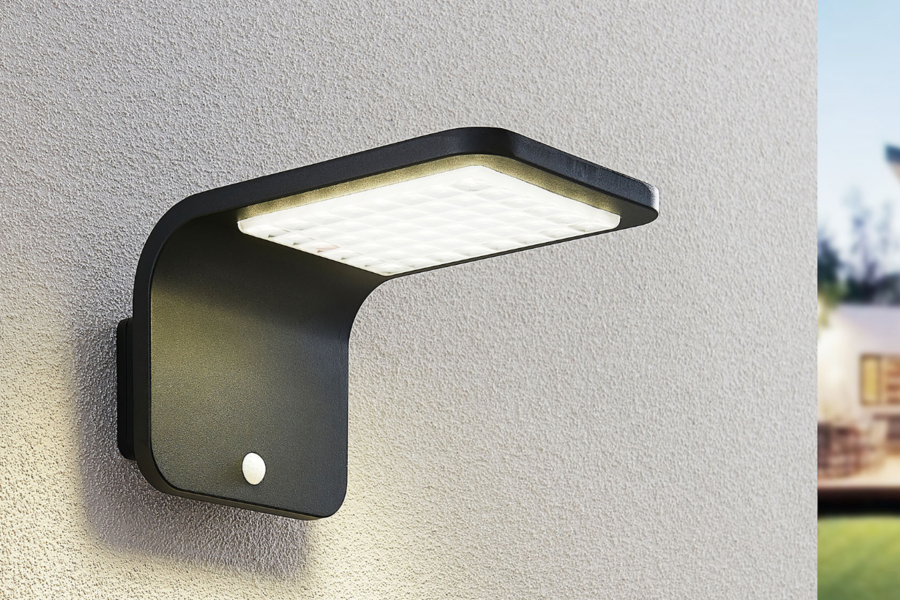Lampenwelt präsentiert die neuen Solarlampen  als Wandleuchte mit Bewegungsmelder an einer Hausmauer.