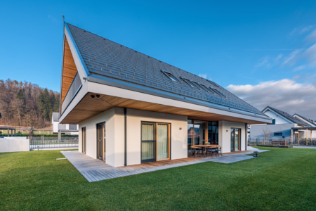 Lumar Haus zeigt ein Einfamilienhaus mit Satteldach, Terrasse mit Sitzgelegenheiten und großem Garten.