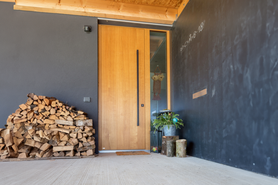Moderne Hauseingangstür aus Holz mit einem seitlichen, raumhohen Glaselement der Firma Maderböck.