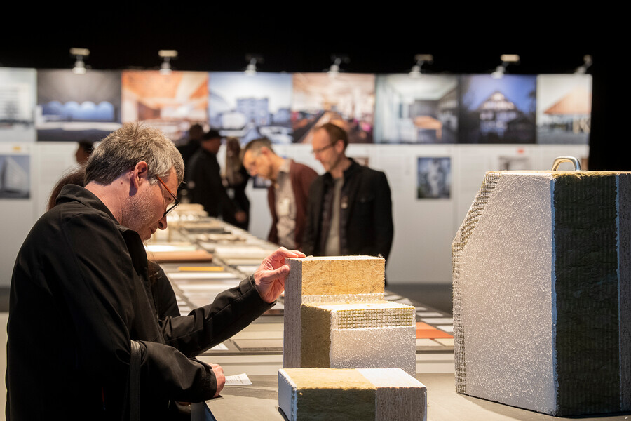 Besucher auf der ARCHITECT @ WORK in Zürich beim Betrachten verschiedener Dämmmaterialien.