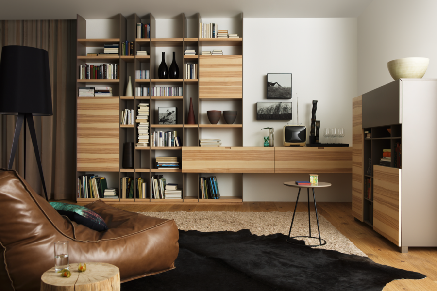 Pointinger wohnen zeigt ein Wohnzimmer mit großem, gemütlichen Ledersessel, Bücherreal und Wandschrank von haas.