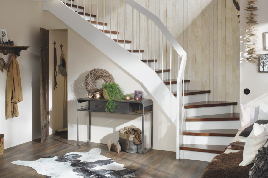 Gemütlich eingerichtetes Vorzimmer im Landhausstil mit einer Treppe - ausgestattet mit dunklen Holzbelägen - von Treppenmeister.