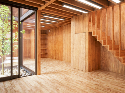 Innenasicht eines modernen, hohen Raumes eines Holzmassivhauses mit Ganzglasfenstern.