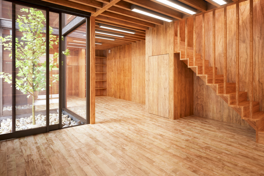 Innenasicht eines modernen, hohen Raumes eines Holzmassivhauses mit Ganzglasfenstern.
