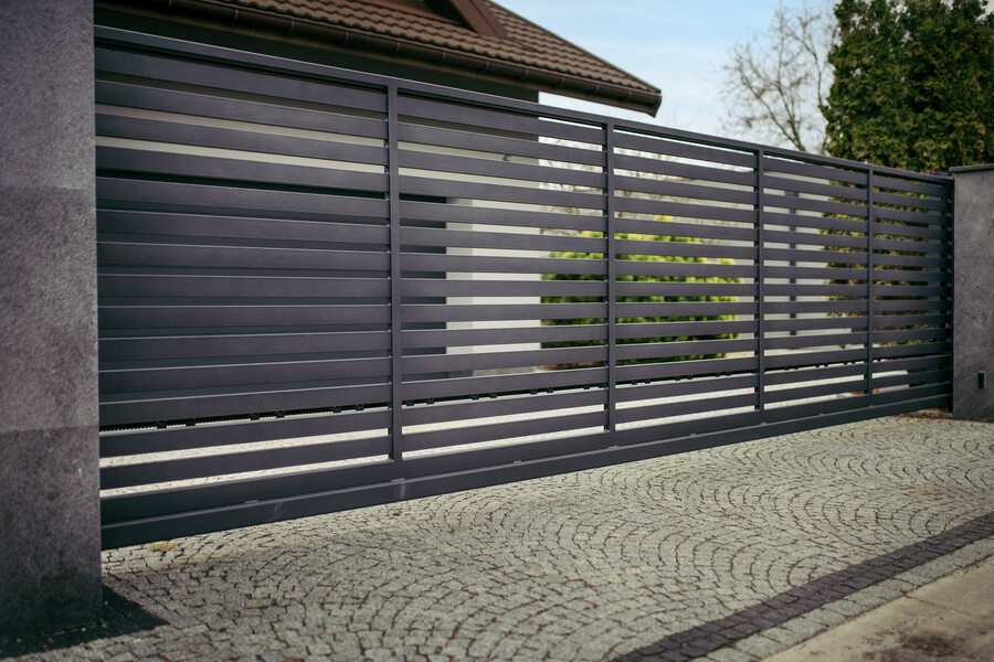 Breites Einfahrtstor im Look eines modernen Gartenzaunes in Anthrazit aus eloxiertem Aluminium mit horizontalen Querstreben.