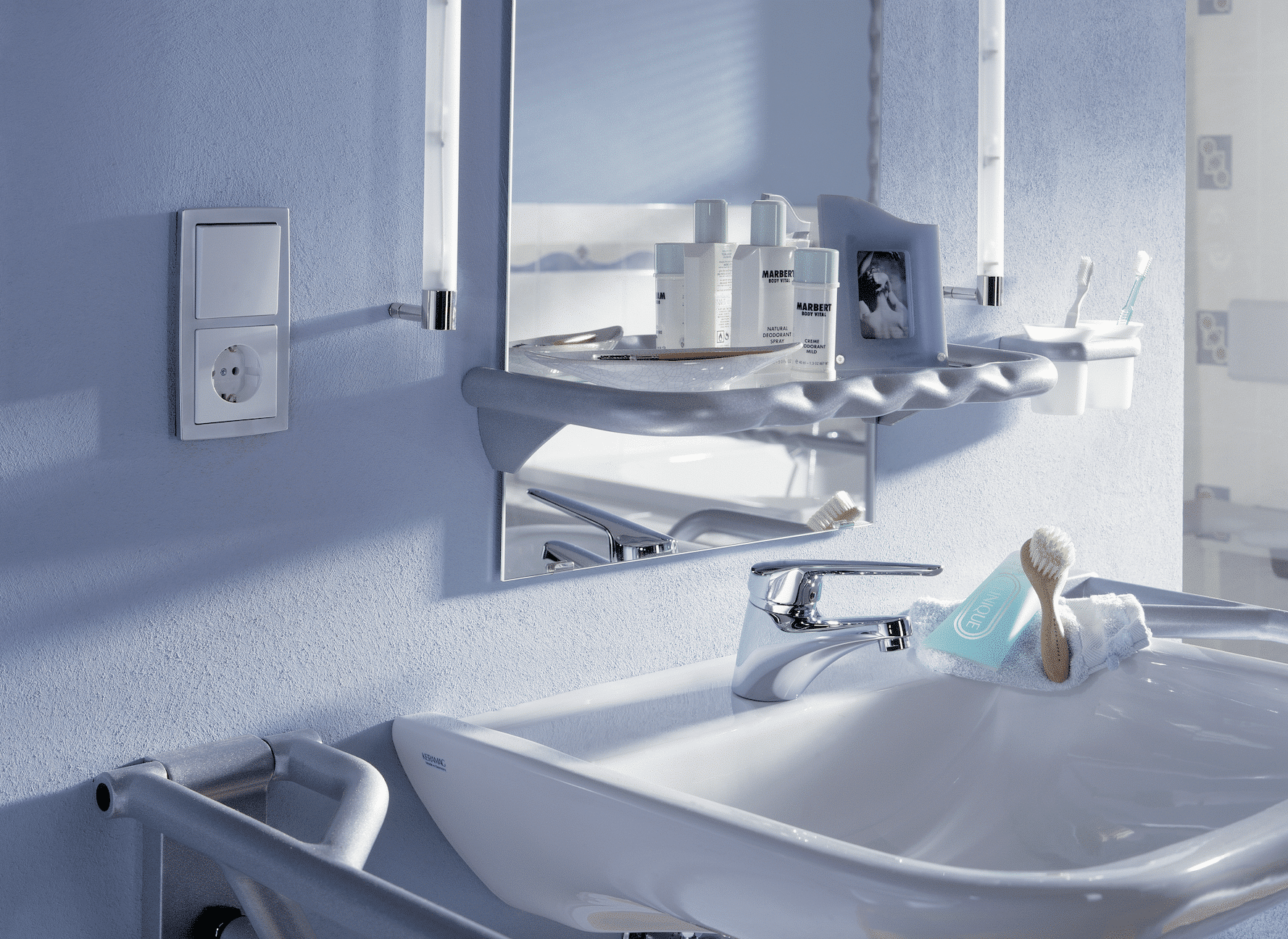 Über dem Waschbecken angebrachter Lichtschalter und Steckdose von ABB Busch-Jaeger.