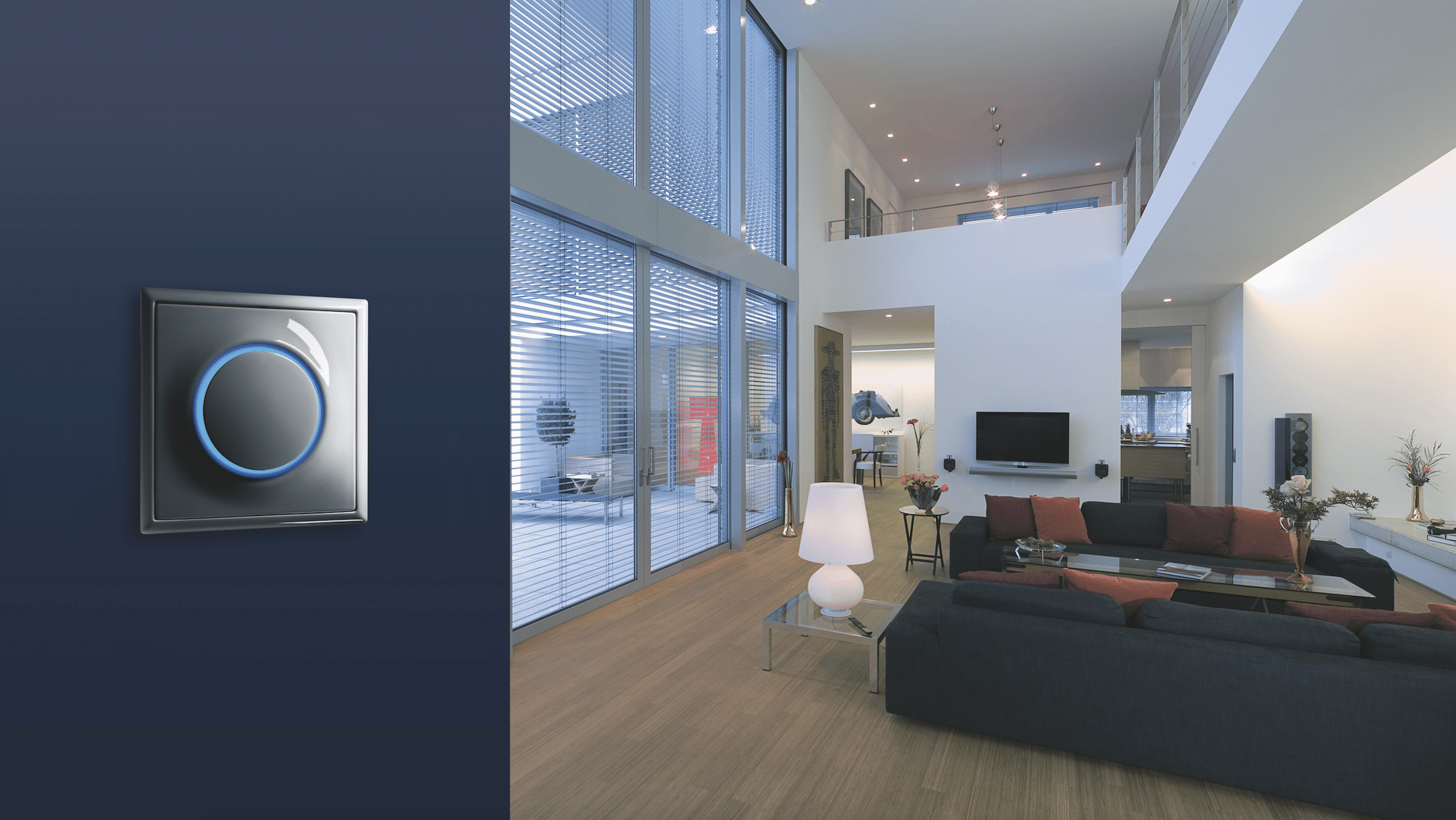 Moderner Impulsschalter von ABB Busch-Jaeger angebracht an blauer Wand mit Wohnlandschaft im Hintergrund.