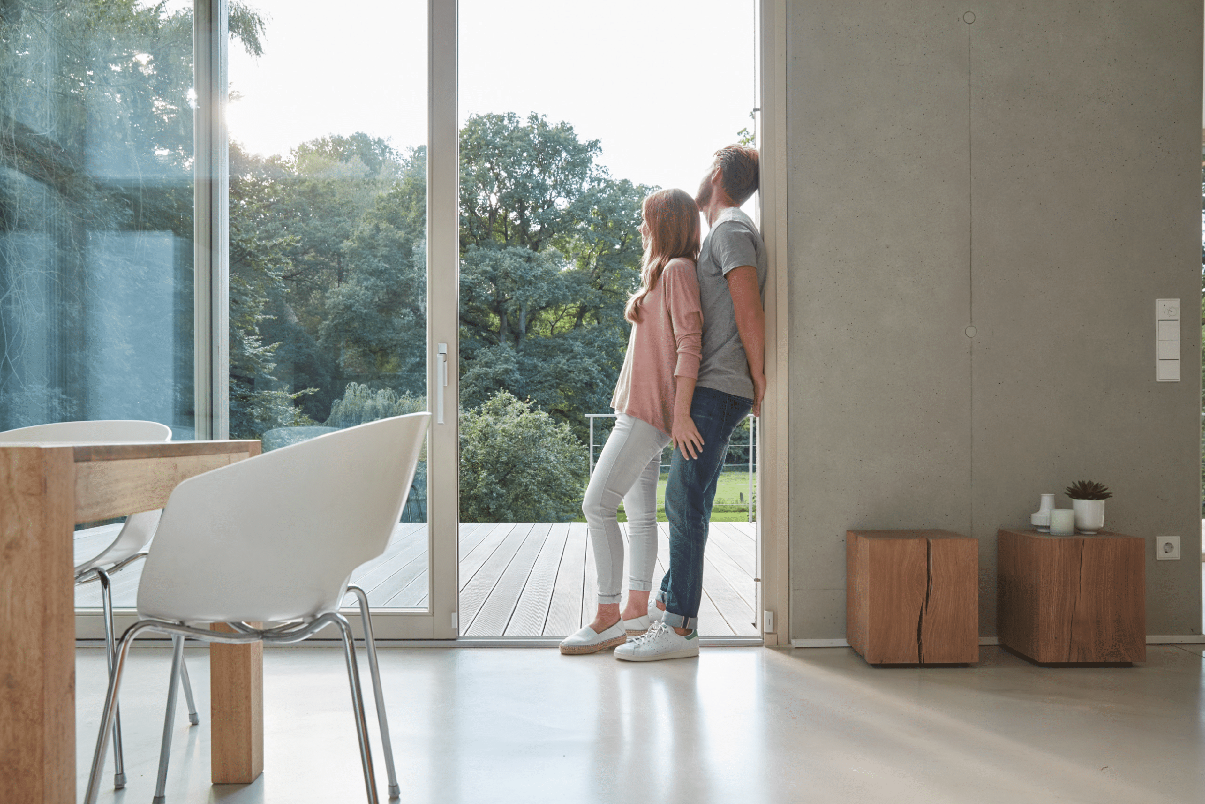 Pärchen genießt Smart Home von ABB Busch-Jaeger in moderner Raumsituation.