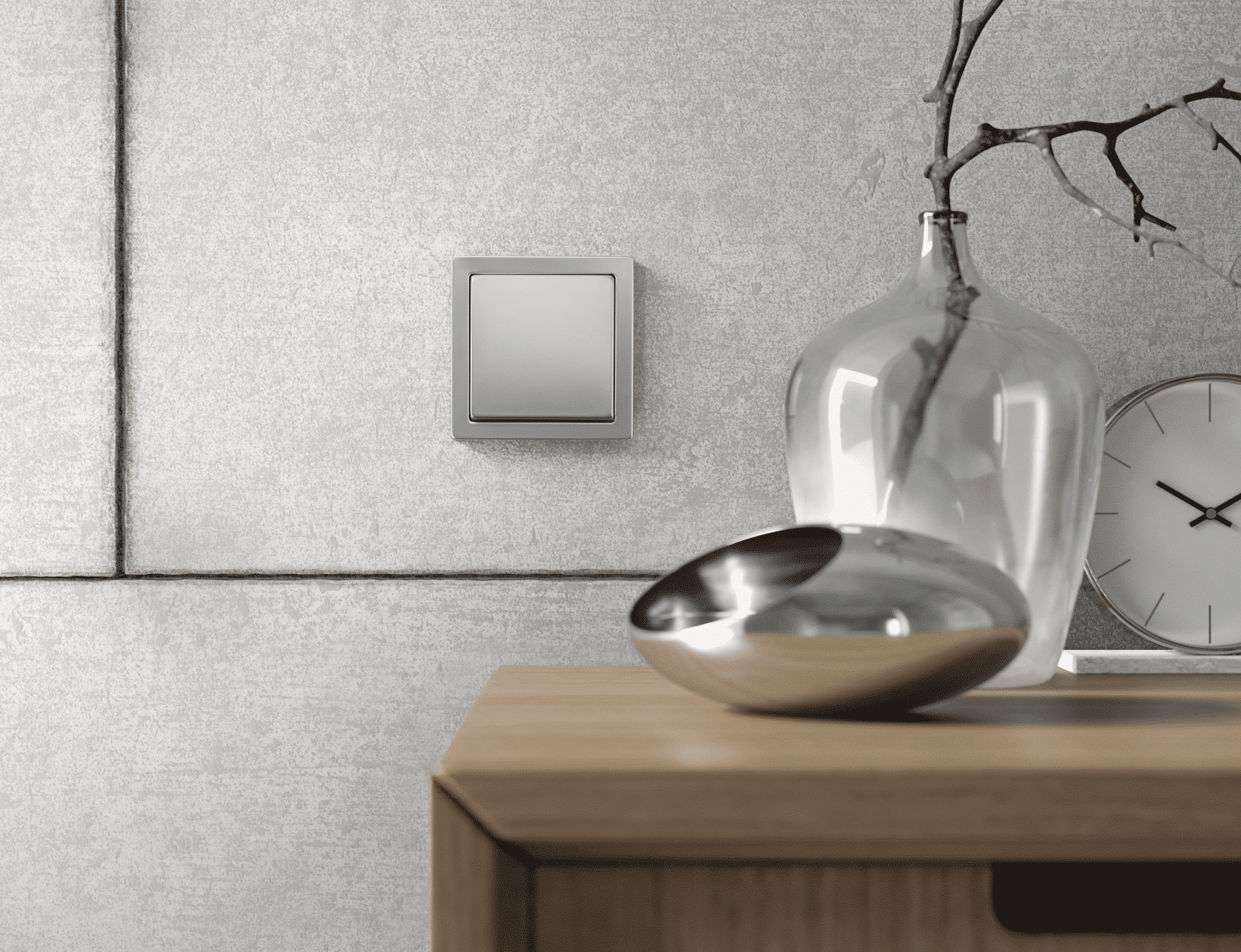ABB - Busch-Jäger zeigt einen silbernen, quadratischen Lichtschalter neben einem Tischchen mit moderner Deko.