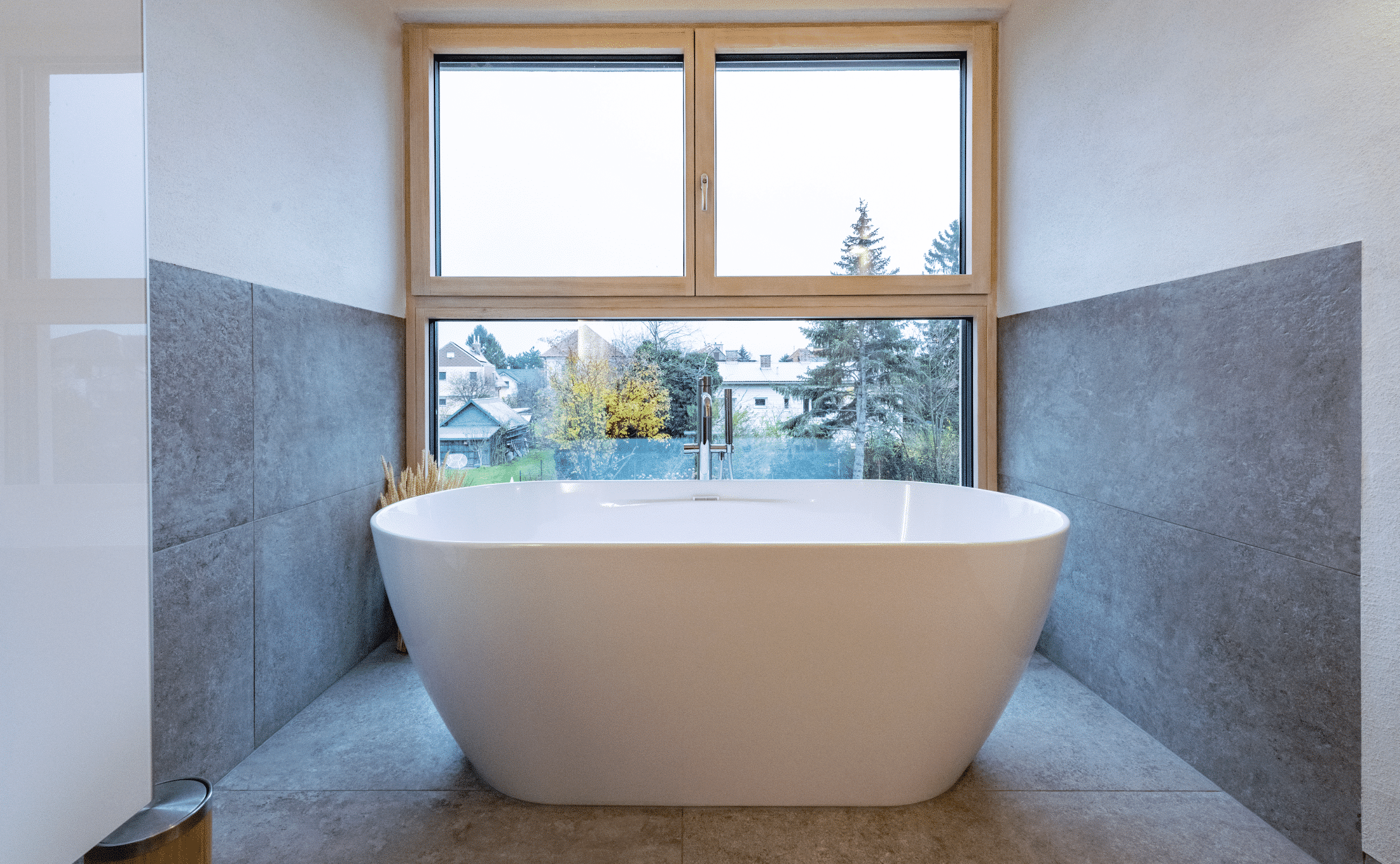 Badezimmer mit freistehender Badewanne und Fensterfront von AL Architekt ZT.