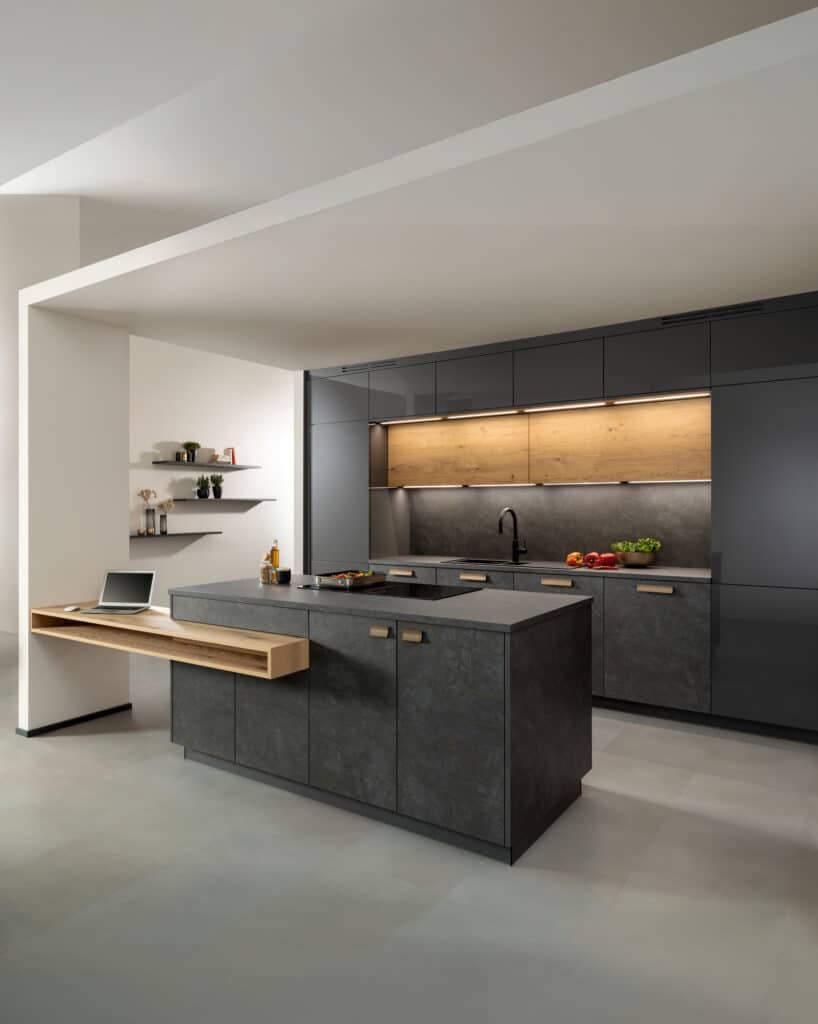ALPHAOMEGA zeigt eine Küche mit Küchenzeile und Kochinsel in Anthrazit mit Patina und einer angestückelten Theke aus Holz.
