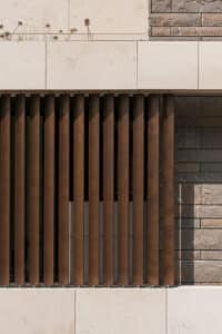 ALURE Outdoorliving zeigt eine Trennwand aus braunen Lamellen in einer Außenwand.