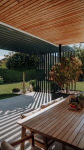 ALURE Outdoorliving zeigt eine Terrasse mit Outdoormöbel mit einer schattenspendenden Pergola aus Aluminium.