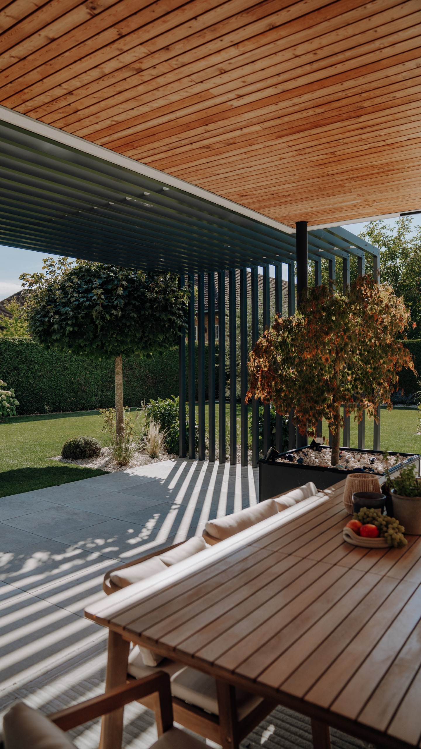 ALURE Outdoorliving zeigt eine Terrasse mit Outdoormöbel mit einer schattenspendenden Pergola aus Aluminium.