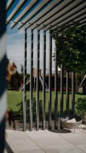 Detailaufnahme eins pulverbeschichteten Aluprofil von ALURE Outdoorliving auf einer Terrasse mit Feuerschale.