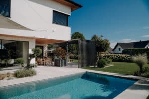 Dekoratives pulverbeschichtetes Aluprofil von ALURE Outdoorliving auf einer Terrasse mit Pool.