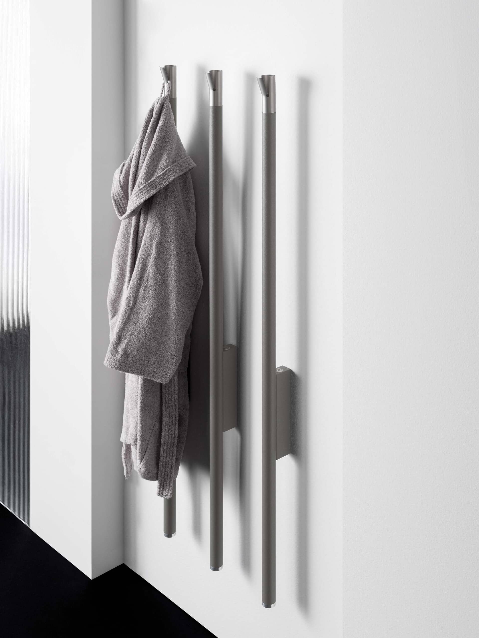 Badezimmer mit 3 wandmontierten senkrechten Handtuchwärmern "Carlo & Tina" im Röhren-look, silber und gebürstet mit aufgehängtem Bademantel von ANTRAX IT.