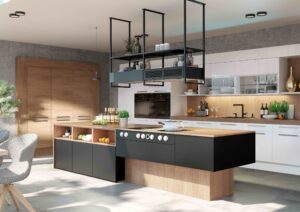 Großzügige, offene Küche mit Essbereich in einem Materialmix aus Schwarz, Weiss und Holz mit Deckenregal im Industrial-Look als Eyecatcher von DAN Küchen gezeigt von Salzburger Bad & Wohnraum.