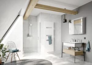 Modernes Dachgeschossbad mit Dusche unter Dachschräge mit Deckenbalken, Walk-in-Dusche mit Glastür, Handtuchheizkörper und Waschtisch und bBeleuchtung im Industrial-Stil von HSK gezeigt von Salzburger Bad & Wohnraum.