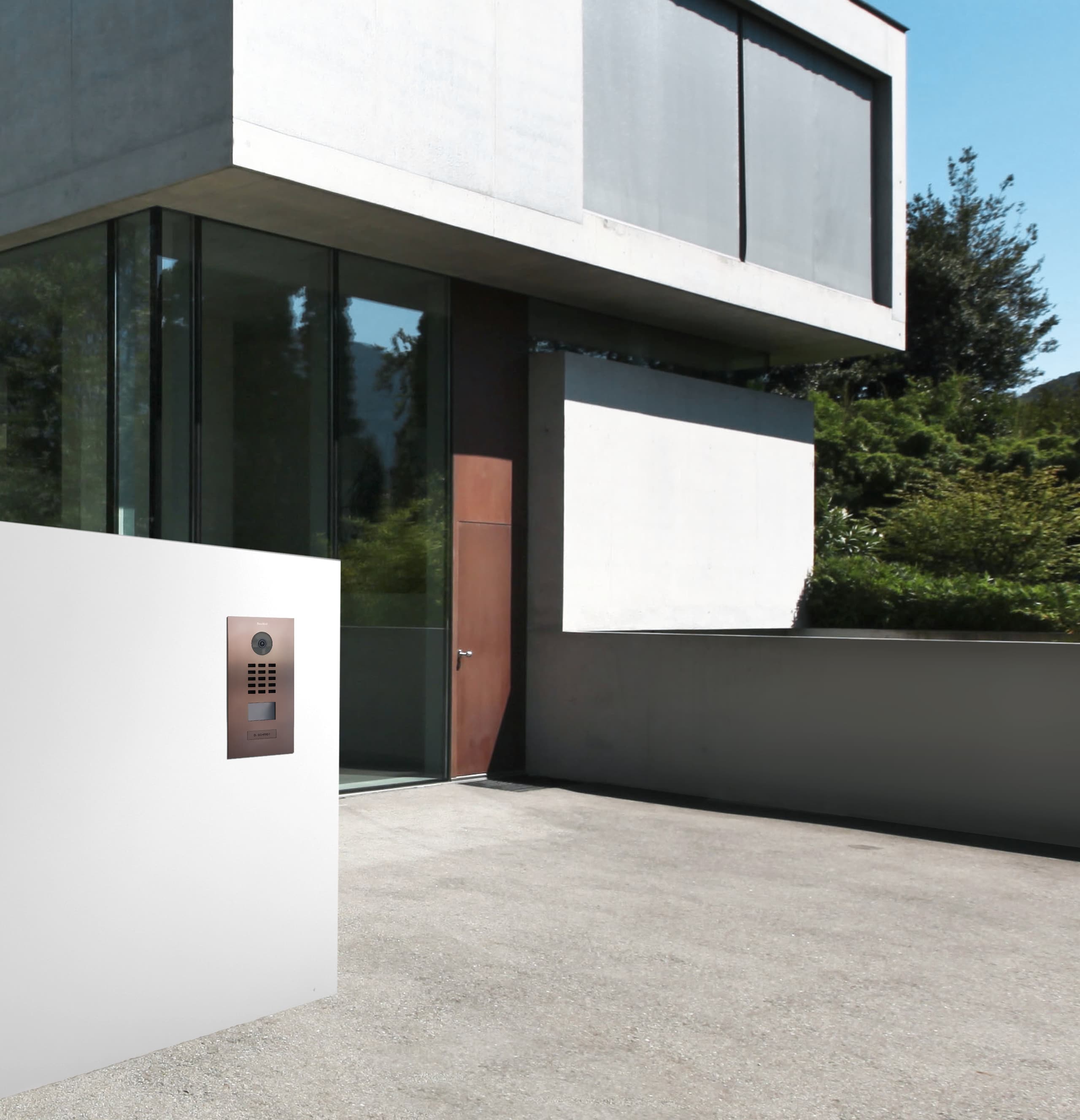 Bird Home Automation zeigt eine Türsprechanlage mit Videofunktion in bronze vor einem modernen Einfamilienhaus.