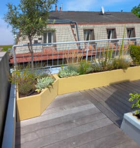 Zwei gelbe Blumenkästen in Sonderform für den Balkon, modern gestaltet und bepflanzt von Blumentrog-Flexi.