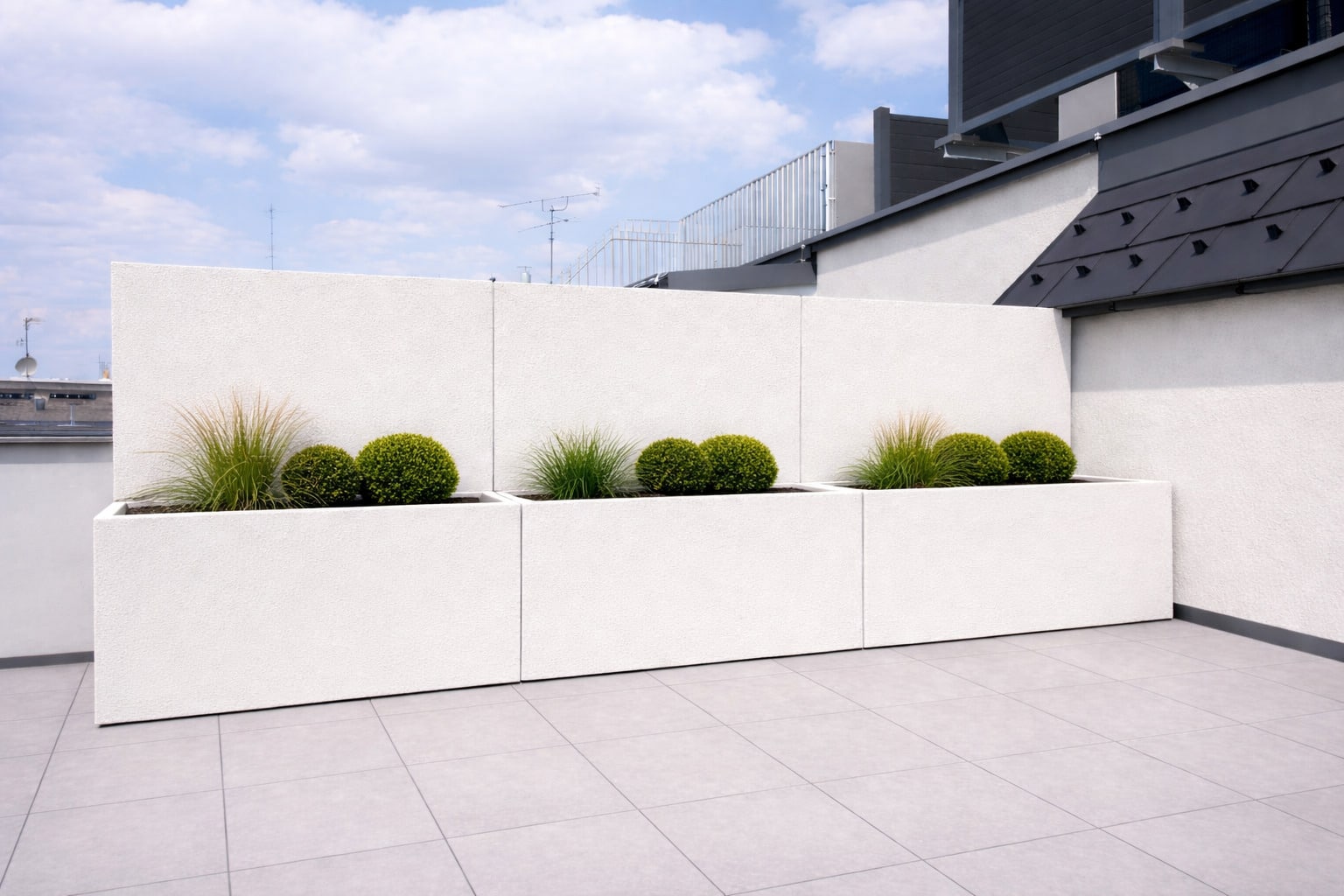 Drei lange, rechteckige Pflanzkübelelemente mit hoher Rückwand die als Sichtschutz dient in Warmweiss-Beige auf einer geräumigen Dachterrasse von Blumentrog-Flexi.