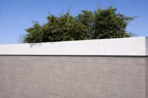 Eine längliche Galerie weißer Pflanzkübel auf einer Sichtschutzmauer von Blumentrog-Flexi.