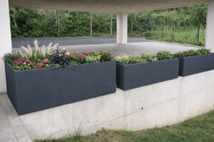 Drei moderne anthrazitfarbene verschieden hohe Pflanzkübel in klarer, rechteckiger Form als stilvolle Carportabgrenzung von Blumentrog-Flexi.
