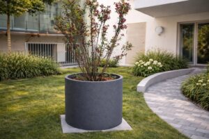 Ein runder, grauer XXL-Pflanzkübel mit Hartschaumkernplatte von Blumentrog-Flexi.