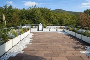 Eine moderne Dachterrasse mit einer Galerie aus bepflanzten, rechteckigen, weißen Pflanzkübeln entlang der Reling sorgt für Wohlbehagen - von Blumentrog-Flexi.