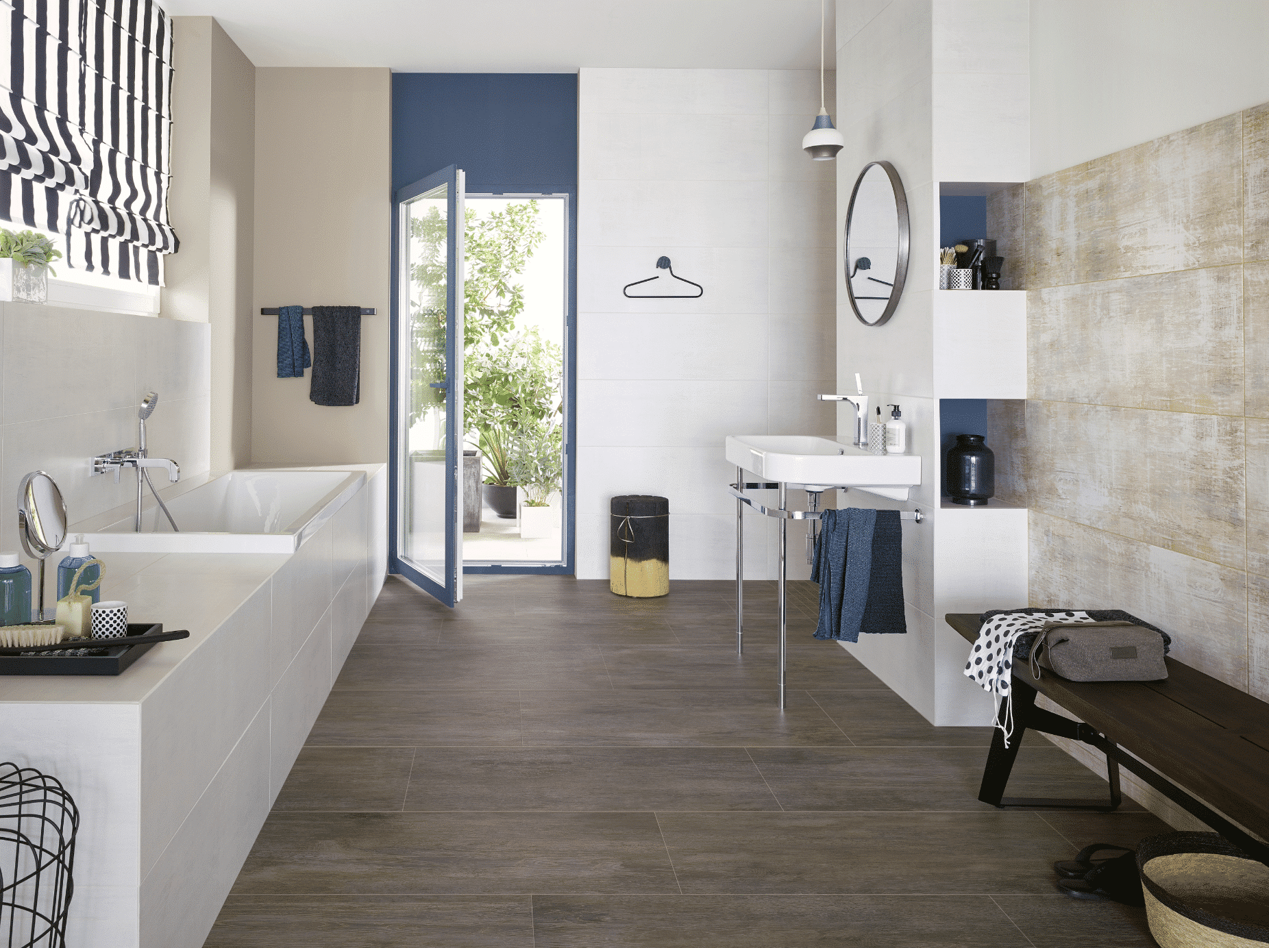 C. Bergmann zeigt ein Badezimmer in blau und weiss mit großen dunklen Fliesen, einem weissen Waschtisch und eine beige geflieste Wand von Agrob Buchtal.