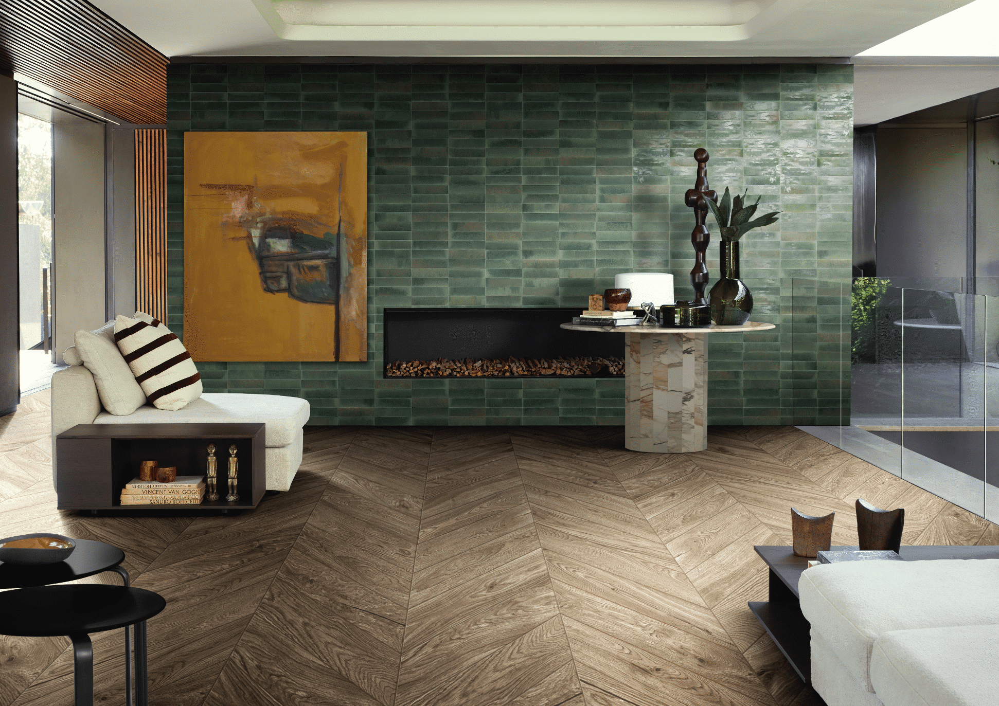 C. Bergmann zeigt ein Wohnzimmer mit Wandfliesen in verschiedenen Grüntönen, einem in der Wand verbauten Kamin und einem schönen Holzboden und gemütlichem Loungesessel von Marazzi.