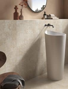 C. Bergmann zeigt Badezimmer mit beige Wandfliesen mit Ornamenten von Abitare.