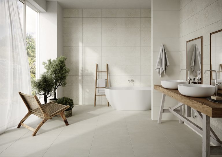C. Bergmann zeigt Badezimmer mit quadratischen beigen Bodenfliesen und beige rechteckige, mit Ornamenten gemusterte Wandfliesen von Agrob Buchtal.