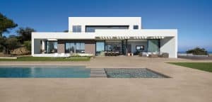 C. Bergmann zeigt eine Flachdach-Villa mit Terrasse, Pool und großformatigen beigen Bodenfliesen von Atlas Concorde.