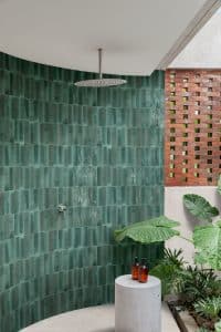C. Bergmann zeigt Badezimmer mit grün glänzenden Stäbchen-Kacheln von Marazzi.
